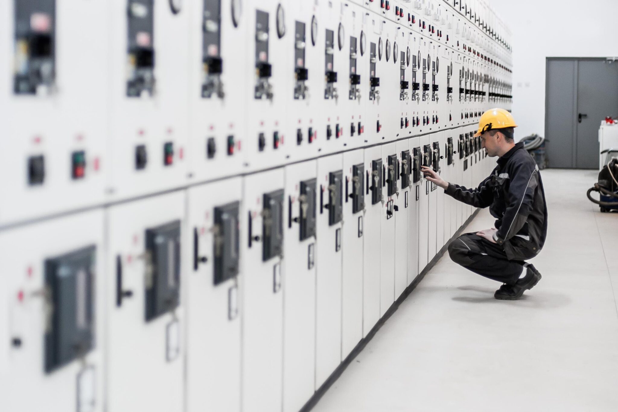 Maintenance engineer testing voltage switchgear and bay control unit