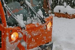 Detail of snow plow truck and blade in action during a heavy snow storm