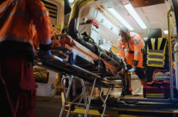 Team of EMS Paramedics React Quick to Bring Injured Patient to Healthcare Hospital and Get Him Out of Ambulance on a Stretcher. Emergency Care Assistants Help Young Man to Stay Alive After Accident.