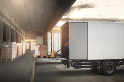 Package Boxes on Pallets Loading into Cargo Container. Trucks Parked Loading at Dock Warehouse. Delivery Service. Shipping Warehouse Logistics. Road Freight Truck Transportation.