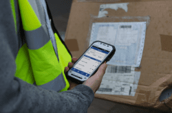 Delivery worker using a handheld device.