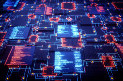 A futuristic design of an integrated circuit with displays showing source code. The image represents an abstract design in the domain of computing, security, engineering, electronics or similar advanced technology. This image is a made up 3D concept render.