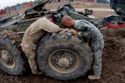 "A U.S. Army mechanic and a truck operator try to troubleshoot a mechanical problem in Ramadi, Iraq. Semi-Fisheye (15mm Fish on Crop-Sensor)."